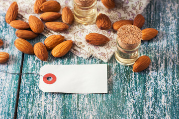 Almond oil in bottle  and nuts on wooden background