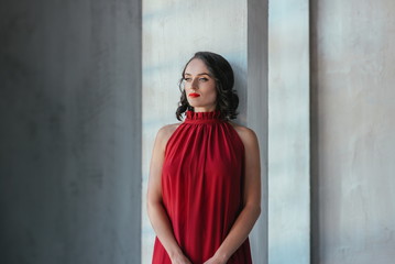 portrait of beautiful young brunette muse woman in red long dress