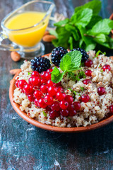 Quinoa salad with berries, mint and walnuts on a dark wooden background. Superfoods  clean eating concept.