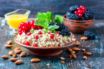 Quinoa salad with berries, mint and walnuts on a dark wooden background. Superfoods  clean eating concept.