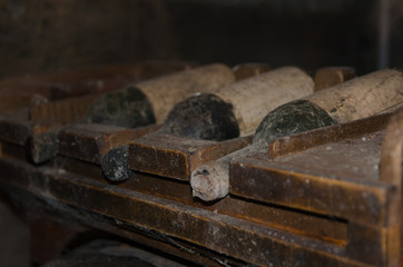 Very old wine bottles overed with dust and cobwebs in wine cellar .Aging Wine background with copy space.