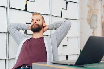 A content man with laptop relaxing at while work