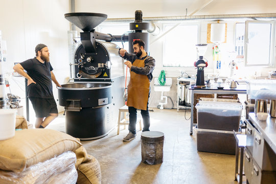 Two men having a conversation over a coffee roasting machine in Sweden