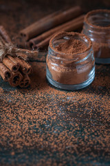 Cinnamon sticks and  powder close up on wooden background, rustic style