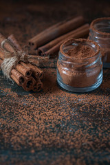 Cinnamon sticks and  powder close up on wooden background, rustic style