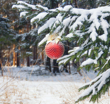 the Christmas fir-tree in snow is decorated with toys