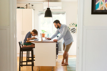Father and son using laptop and digital tablet at home