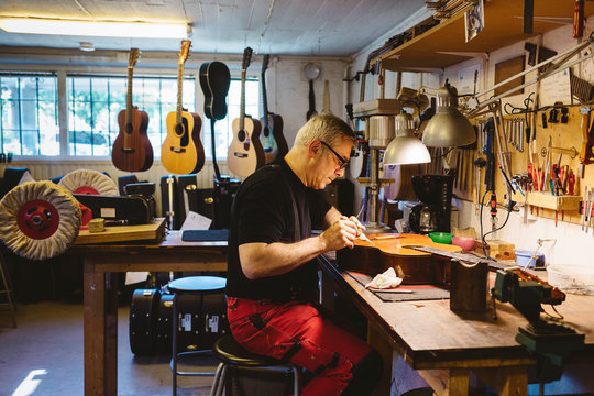 Craftsman working in guitar making workshop