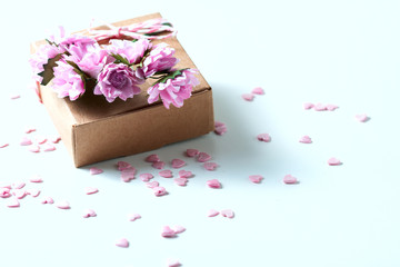 Kraft box and pink roses on white table, concept of Valentine's Day, holiday. Selective focus. Red heart.