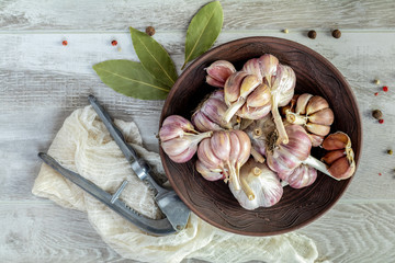 Fresh garlic heads, cloves set on a light gray wooden surface
