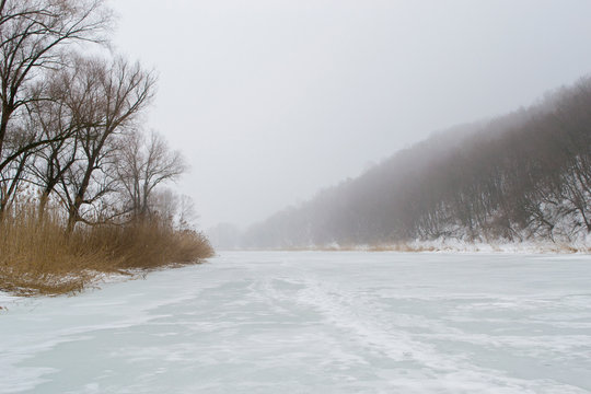 Winter frozen river with fog in the morning.
