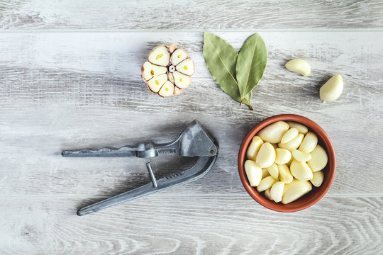 Fresh garlic heads, cloves set on a light gray wooden surface
