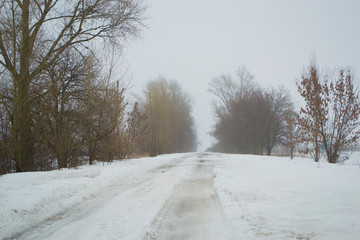 Snowy weather on the empty road, danger, winter.