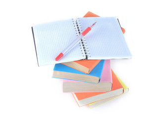 open the notebook, pen and a stack of books on white background