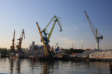 Fototapeta na wymiar Ganrty cranes in the sea port on the coast of the Azov Sea