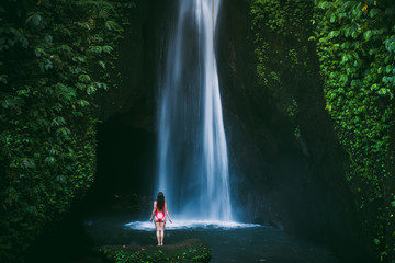 Woman traveler and waterfall in Bali, Indonesia