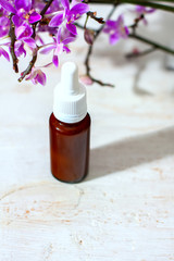 spa setting with cosmetic cream, gel and purple orchid on white wooden table background.