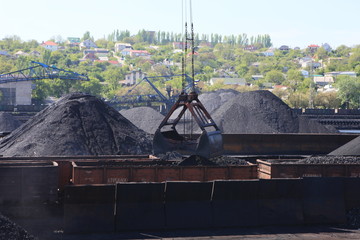 Seaport crane grabs rubble from cargo bay with a ladle