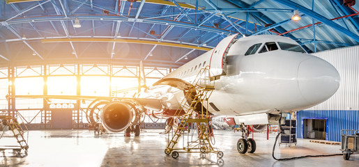Maintenance and repair of aircraft in the aviation hangar of the airport, view of a wide panorama.