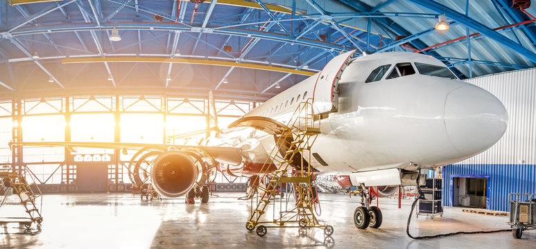 Fototapeta Maintenance and repair of aircraft in the aviation hangar of the airport, view of a wide panorama.