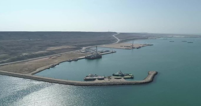 4K Aerial video filming of a container ship fixed in the port of Bautino on the shores of the Caspian Sea, Kazakhstan