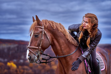 Portrait of a young beautiful woman with long brown hair. Woman on a horse walk.