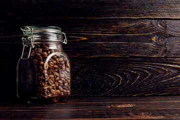 A can of coffee beans stands on a wooden table. Place for text, copy space.