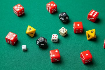 Collection of colored gaming dice cubes on green table