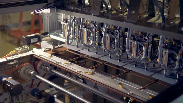Solar cells are being put into a stencil plate by a factory machine