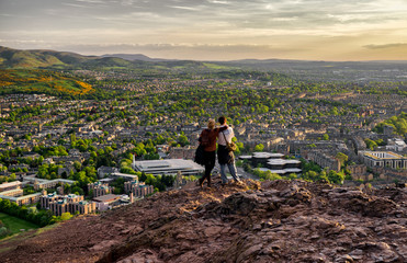 Lovers looking from hill to the city