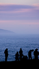 Gente mirando al mar en un atardecer de invierno