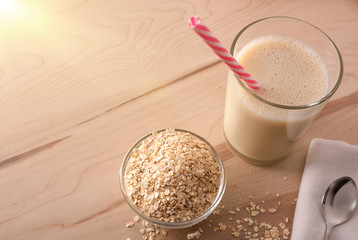 Oat drink in glass and cereal flakes top view