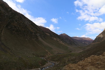 Small lake passing through between the mountains under blue sky