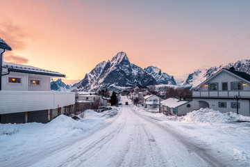 House covered snow with road surrounded with mountain at sunset