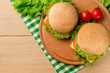 Vegan burgers with fresh vegetables on rustic wooden table, top view. Healthy fast food background with copy space.