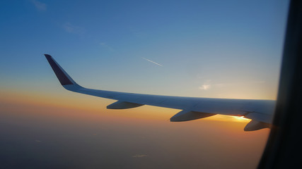 Airplane flying which beautiful view of Sunset sky on airplane, plane window,relax flight in a vacation concept