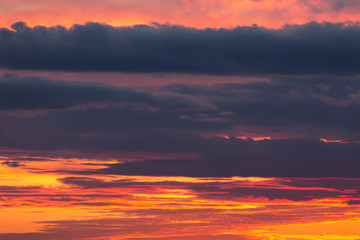 Beautiful dramatic sunset orange sky with blue violet clouds
