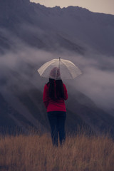 Back view of lonely young woman long hair and red dress  with umbrella ,fog and mist mood concept.