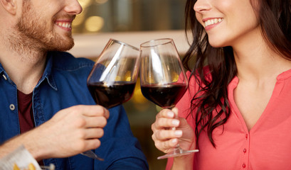 celebration, holidays and people concept - happy couple drinking red wine at restaurant