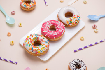 Preparation for the holiday. Colorful american donuts on pink background