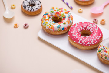 Preparation for the holiday. Colorful american donuts on pink background