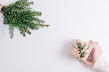 Woman holding a Christmas gift on a wooden background