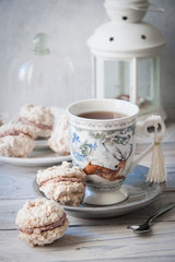Homemade coconut macaroons with mascarpone cream, and hot tea on winter holidays background