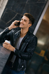 Happy man standing and talking to someone over smart phone