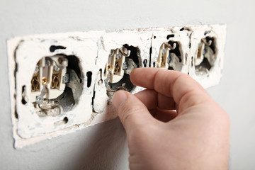 Electrical short circuit, dangerous use of electricity. Damaged socket in the wall.