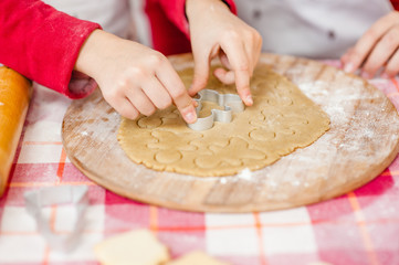 close-up of a children's hands cut out dough cookies