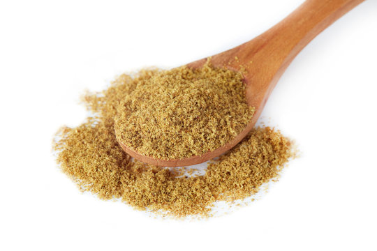 Ground cumin powder in wooden spoon isolated on white background