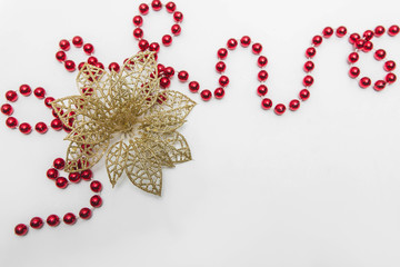 Xmas red beads on the white table with a flower