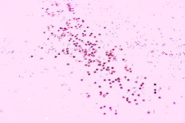 Pink confetti and stars and sparkles on pink background.