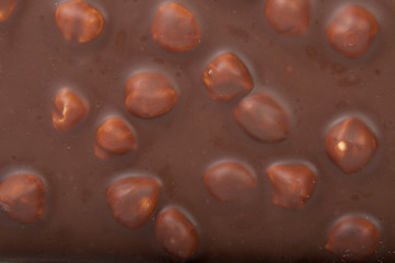 Tasty chocolate with hazelnuts background